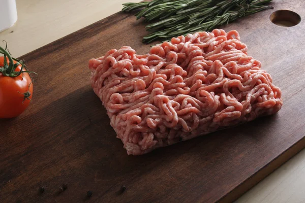 Gehakt varkensvlees op een houten achtergrond — Stockfoto