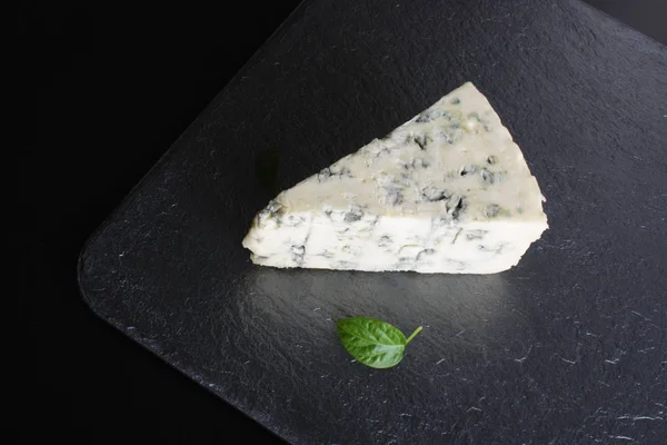 Голубой сыр на каменном фоне черный — стоковое фото