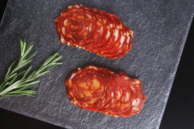 Baharatlı İspanyol domuz sosis slicingon karanlık bir taş arka plan