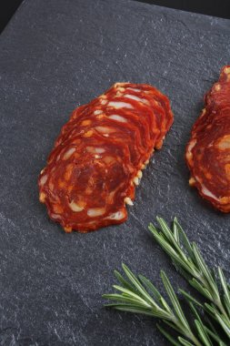 Baharatlı İspanyol domuz sosis slicingon karanlık bir taş arka plan