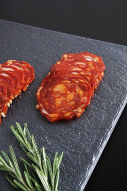 Baharatlı İspanyol domuz sosis slicingon karanlık bir taş arka plan