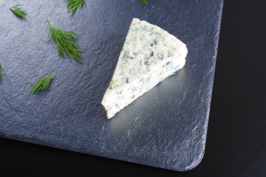 karanlık bir taş zemin üzerine mavi peynir