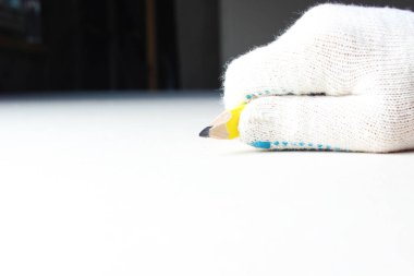 Elle inşa eldiveninde sarı kalem var.