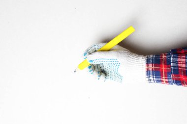 Elle inşa eldiveninde sarı kalem var.