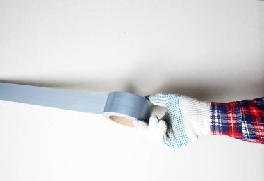 İnşaat bandı gümüş eldivenli el.