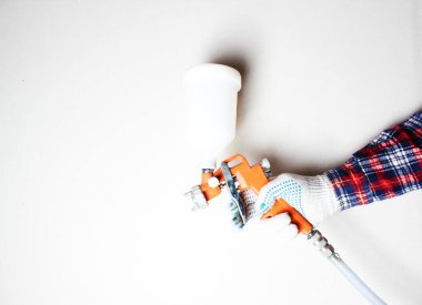 hafif arkaplanda eldiven içinde turuncu boya fırçası