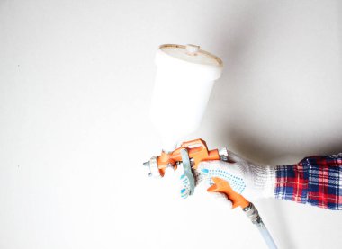 hafif arkaplanda eldiven içinde turuncu boya fırçası