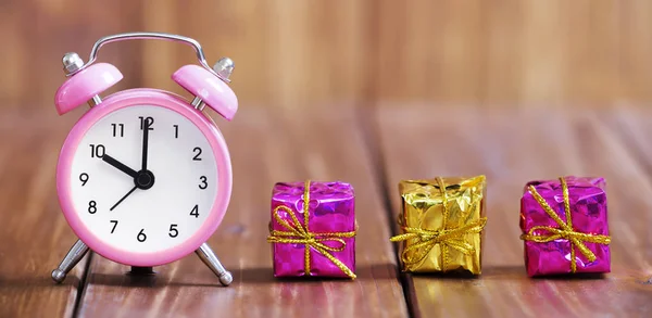 Christmas shopping, time to gift. Pink alarm clock and gift boxe — Stock Photo, Image