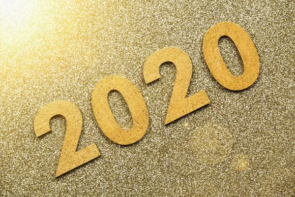 Glitter textured gold party background of 2020 happy new year