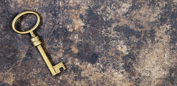Gammal gyllene nyckel på en rostig grunge metall bakgrund, fly rum c — Stockfoto