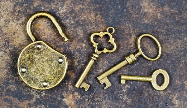 Keys and unlocked padlock on a rusty grunge metal background, es