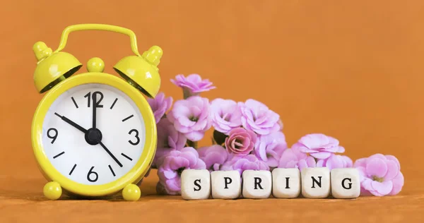 Voorjaar Lente Zomertijd Concept Gele Wekker Bloemen Oranje Achtergrond Kopieerruimte — Stockfoto