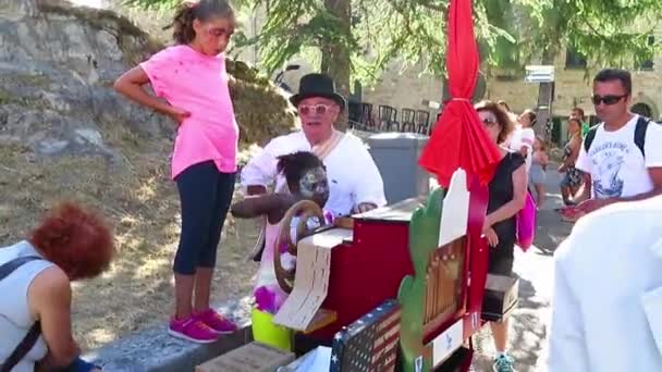 San Leo - Organ-grinder is onderwijs de kinderen hun ambacht — Stockvideo