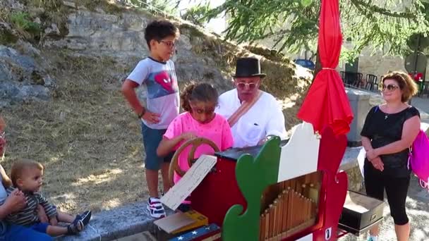 San Leo - orgel-grinder undervisar barnen sitt hantverk — Stockvideo