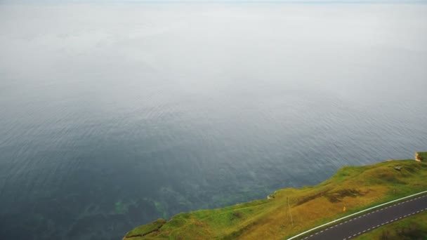 大気の穏やかな海の上を飛ぶ美しい浸食された海岸線の岩だらけの海岸線で驚くべき映画撮影ドローンの傾き — ストック動画