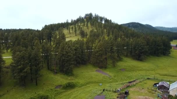 drone volant vers l'avant s'élevant au-dessus de petit ranch agricole et grande colline pour révéler incroyable paysage forestier national skyline 