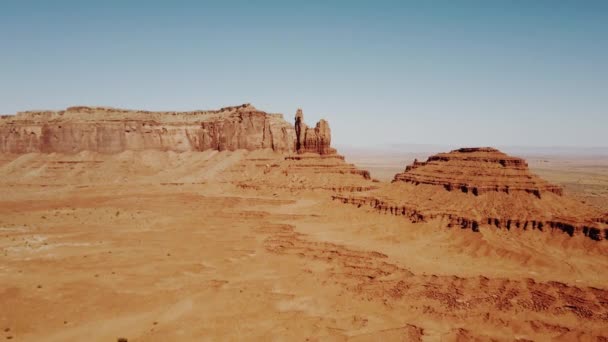 无人机飞越阳光明媚的干旱沙漠 向大岩石山和晴朗的蓝天飞行在纪念碑谷国家公园 — 图库视频影像