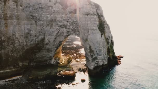有名な白亜の海岸沿いの崖で壮大な自然の岩のアーチを飛ぶ無人機 — ストック動画