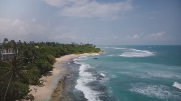 在异国情调的度假胜地海滩拍下的无人驾驶飞机飞越的照片 小船上的热带树木泡沫般的波浪在美丽的海岸上荡漾着 — 图库视频影像