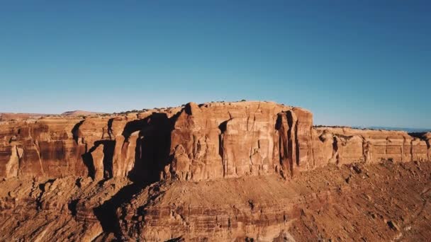 息をのむ岩壁キャニオン スカイラインと壮大な日当たりの良い砂漠の荒野を明らかにするための山の尾根上に上がってドローン — ストック動画