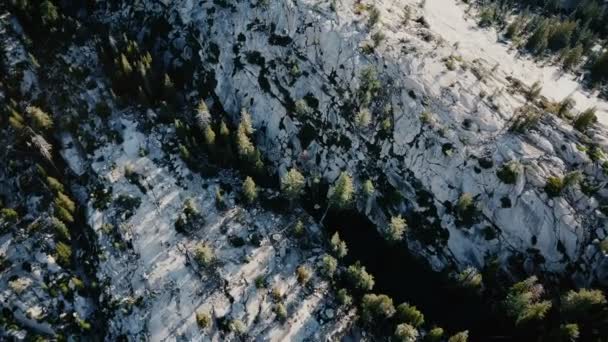 drone vue de dessus survolant une incroyable crête rocheuse de montagne blanche couverte de pins au parc national de yosémite ensoleillé 