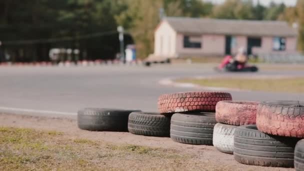 Motoristas Kart Movendo Uma Pista Kart Pneus Coloridos Perto Pista — Vídeo de Stock