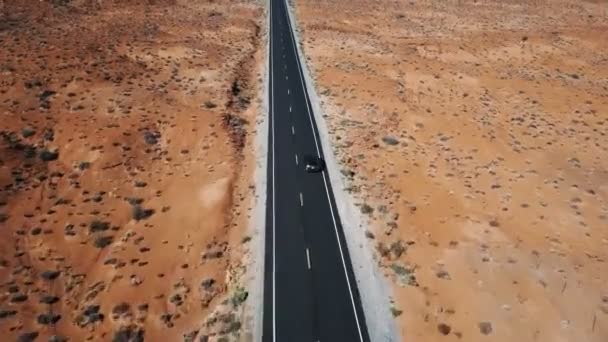 Drone Volgende Inzoomen Zilveren Auto Rijden Langs Zonnige Amerikaanse Woestijn — Stockvideo