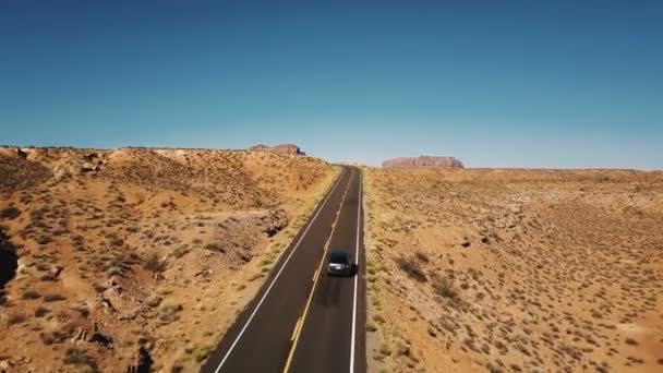 无人驾驶飞机在空旷的沙漠道路上飞驰而上 展现了美国名胜古迹谷地令人叹为观止的高山天际线 — 图库视频影像