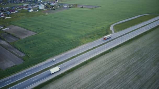 フィールドと村のドローンと高速道路の空中パノラマ4Kのパンニング傾斜ショット物流輸送ネットワーク産業 — ストック動画