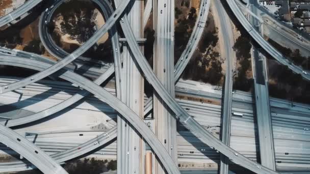 ロサンゼルスの信じられないほど複雑な複数のレベルの道路交差点を通過するトラフィックのトップビューロックダウンショット — ストック動画