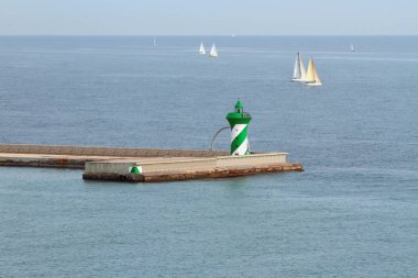 İskelede işaret ve denizde Yelkenli Yatlar