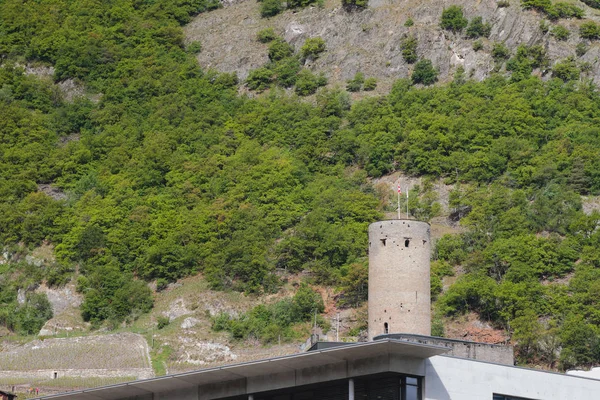Slope of mountain and medieval tower. Martigny, Valais, Switzerland — Stock Photo, Image