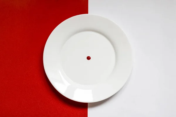 Fehér lemez piros cseppekkel piros-fehér alapon — Stock Fotó