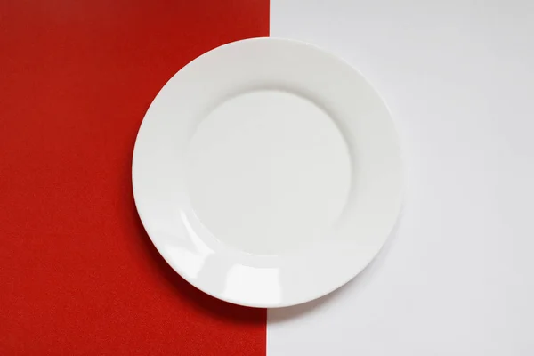 Töm vit platta på en röd och vit bakgrund Stockbild