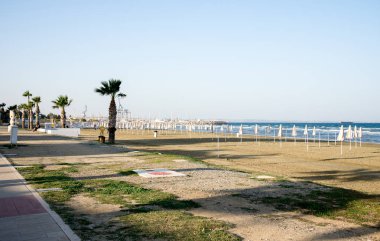Larnaka katlanmış şemsiyelerle Finikoudes plaj kışın boş