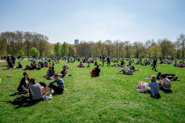 Londra, İngiltere, Nisan 2017: İnsanlar piknik ve yeşil park güneşli bahar hava keyfini çıkarın