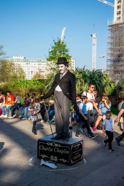 Londra, İngiltere, Nisan 2017: Sokak sanatçıları Jubilee bahçeleri ve London Eye Charlie Chaplin gibi giyinmiş birini