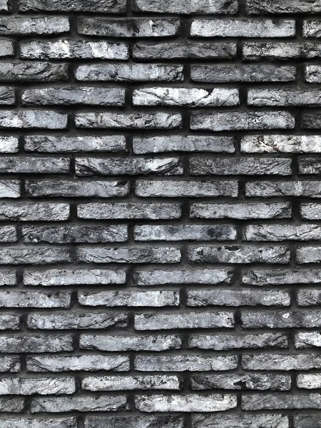 A gray brick wall photographed from a low point. texture of a large number of bricks going into perspective. brick gray building. Such a brick can be used in the interior