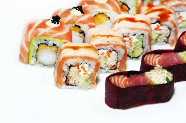 Parlak bir ışıkta tabağa serilmiş lezzetli taze suşi. Japon yemeği. Büyük suşi parçaları güzel bir tabağa serilmiş ve beyaz üzerine izole edilmiş.