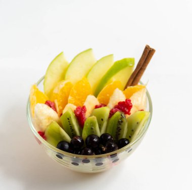 Beyaz arka planda şeffaf cam tabakta meyve salatası. Beyaz arka planda izole edilmiş taze meyve salatası.