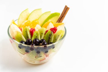 Beyaz arka planda şeffaf cam tabakta meyve salatası. Beyaz arka planda izole edilmiş taze meyve salatası.