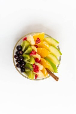 Beyaz arka planda şeffaf cam tabakta meyve salatası. Beyaz arka planda izole edilmiş taze meyve salatası.