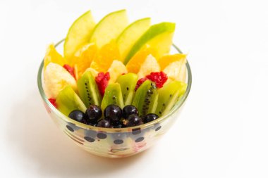 Beyaz arka planda şeffaf cam tabakta meyve salatası. Beyaz arka planda izole edilmiş taze meyve salatası.