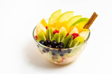 Beyaz arka planda şeffaf cam tabakta meyve salatası. Beyaz arka planda izole edilmiş taze meyve salatası.