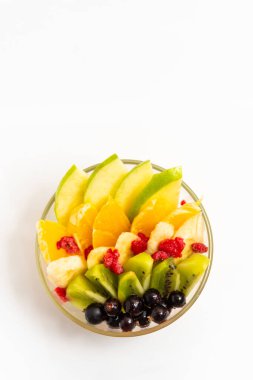 Beyaz arka planda şeffaf cam tabakta meyve salatası. Beyaz arka planda izole edilmiş taze meyve salatası.