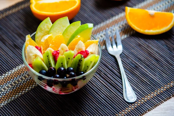 Ensalada Frutas Plato Vidrio Transparente Servido Una Estera Bambú Oscuro — Foto de Stock