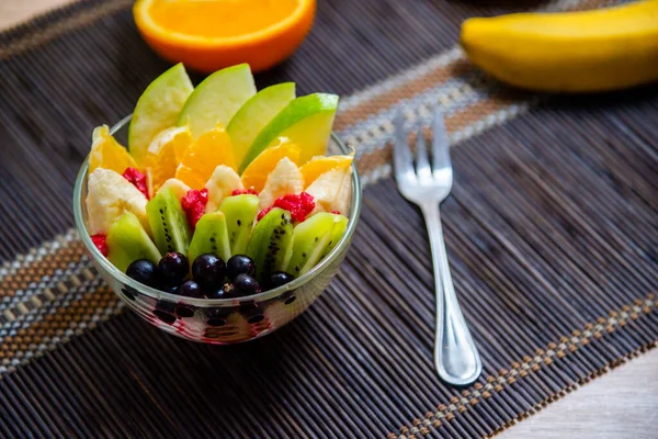 Salada Frutas Uma Placa Vidro Transparente Servida Tapete Bambu Escuro — Fotografia de Stock