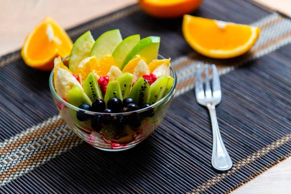 Obstsalat Einem Transparenten Glasteller Serviert Auf Einer Dunklen Bambusmatte Vor — Stockfoto