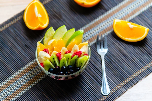 Obstsalat Einem Transparenten Glasteller Serviert Auf Einer Dunklen Bambusmatte Vor — Stockfoto