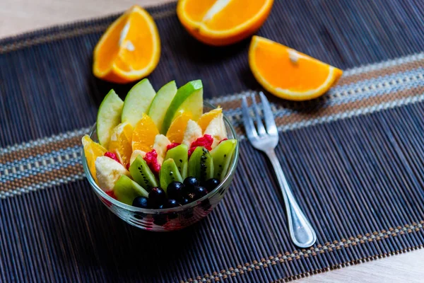 Fruit Salad Transparent Glass Plate Served Dark Bamboo Mat Background — Stock Photo, Image